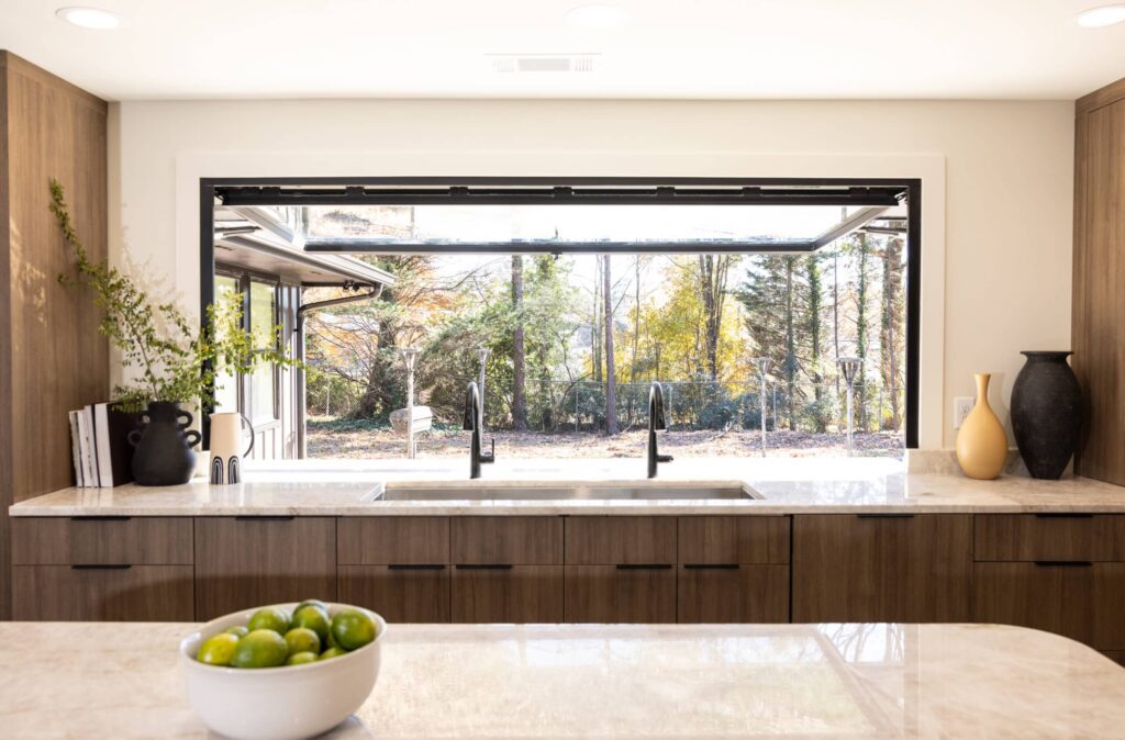 Wide kitchen counter and sink area with the motorized window fully retracted upwards, showcasing the large, unobstructed opening and seamless serving access.